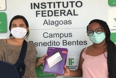 Coordenadora de Assistência Estudantil, Sidiane Batista entrega tablet a estudante do Campus Benedito Bentes