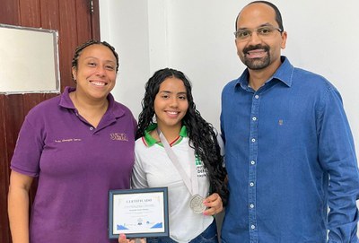 Fernanda Gomes recebeu o prêmio das mãos da professora Elisangela Santos, coordenadora do projeto “Construindo Talentos para as Olimpíadas de Química”, e do professor Filipe Augusto de Jesus, coorientador da iniciativa.