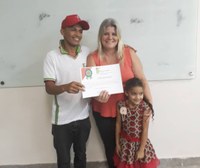 Professora Ana Luiza Fireman entrega certificado a aluno da EJA