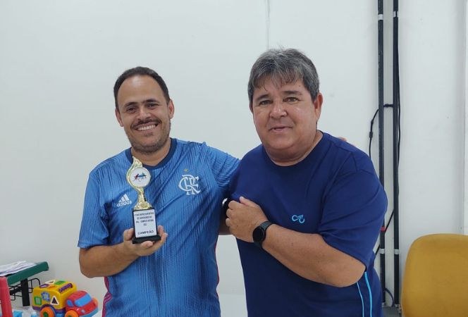 Organizador do evento, Elias Feitosa, entrega troféu para Flávio Pasciência, campeão da modalidade Tênis de Mesa